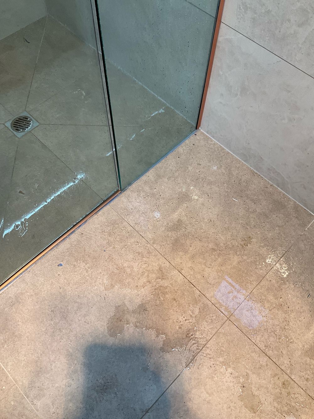 Water escaping the shower recess onto the bathroom floor, found during a pre-handover inspection in Werribee